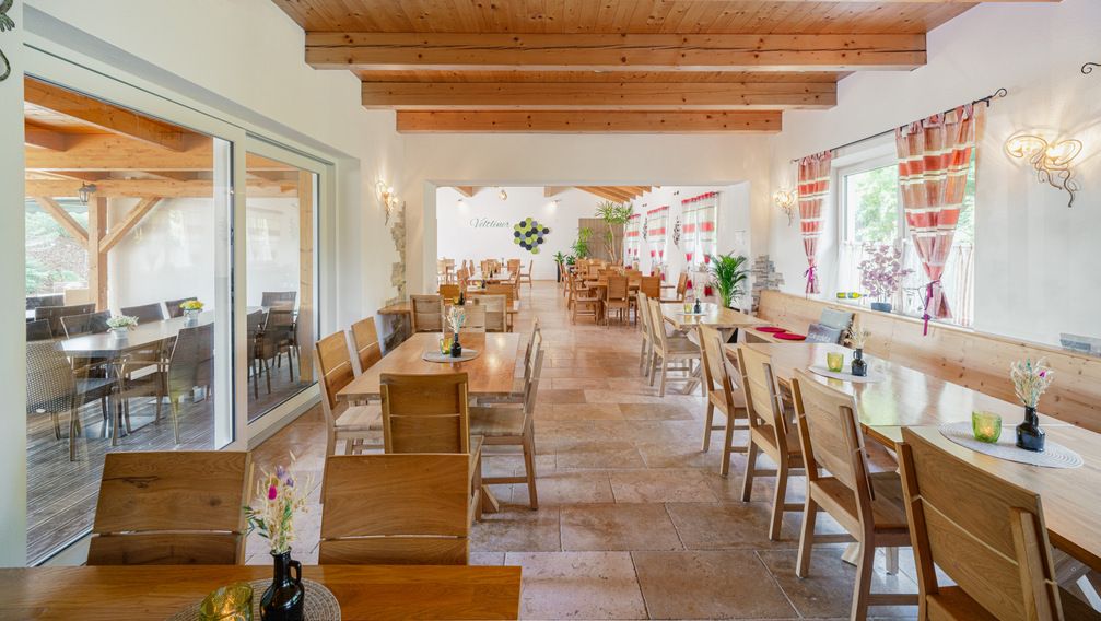 Egy hangulatos borozó belső nézete, fából készült bútorokkal és dekoratív függönyökkel.