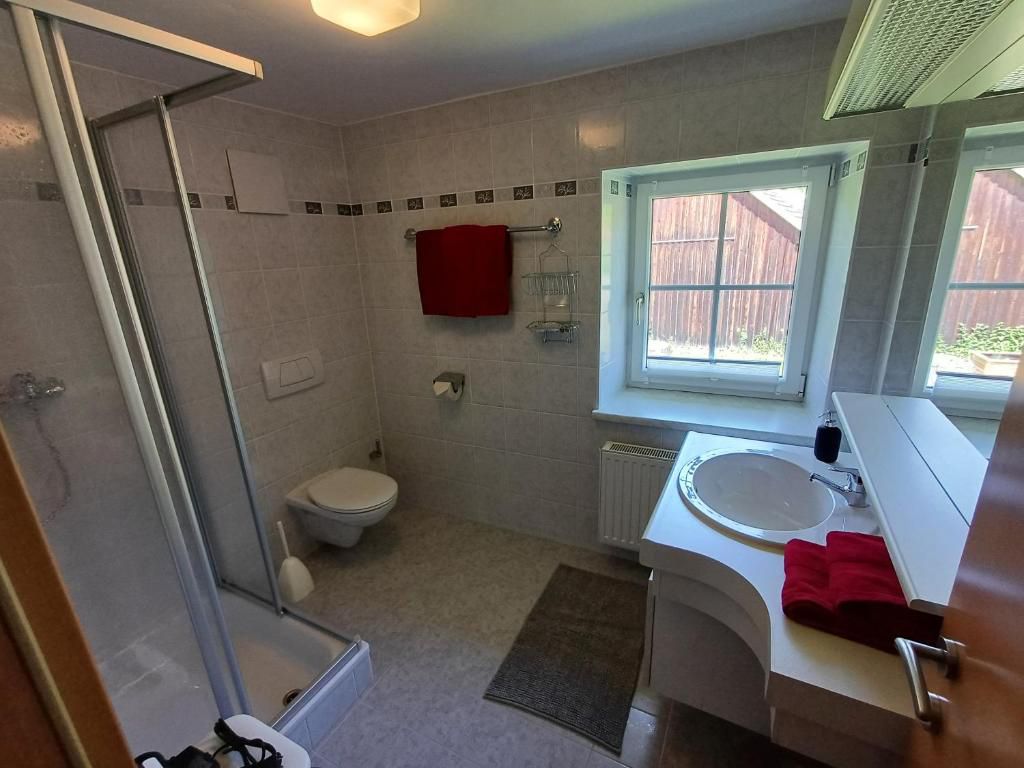 Modern fürdőszoba zuhanyzóval, WC-vel és mosdóval.