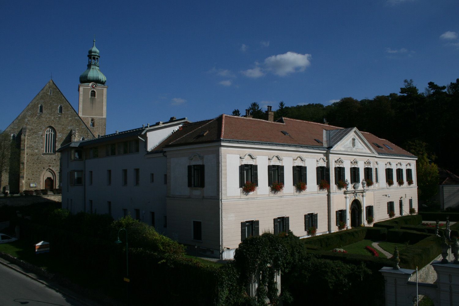 Schloss Großrußbach oktatási központ a templommal a háttérben.