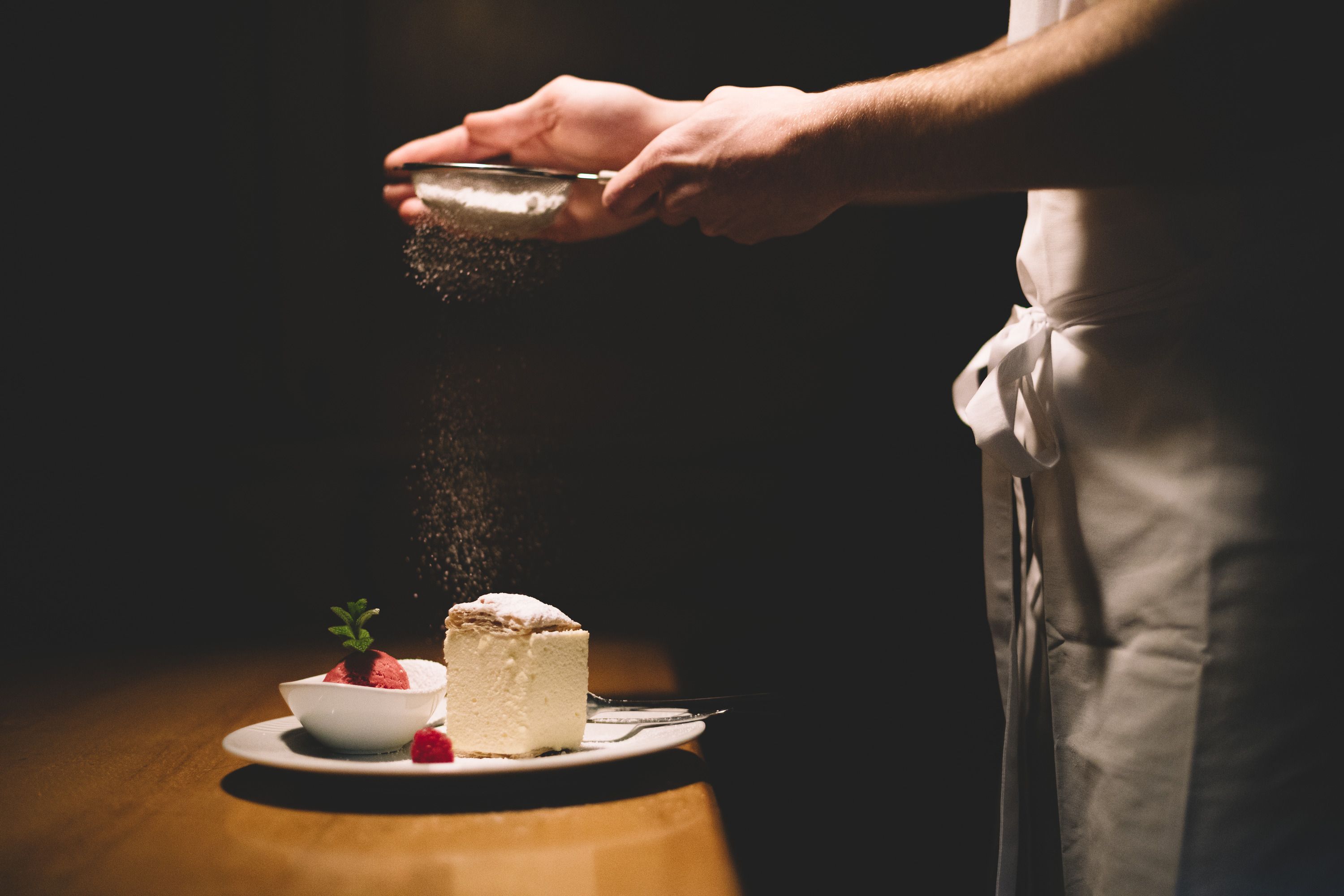 Egy tányér krémszelet és málnaszörbet, porcukorral megszórva.