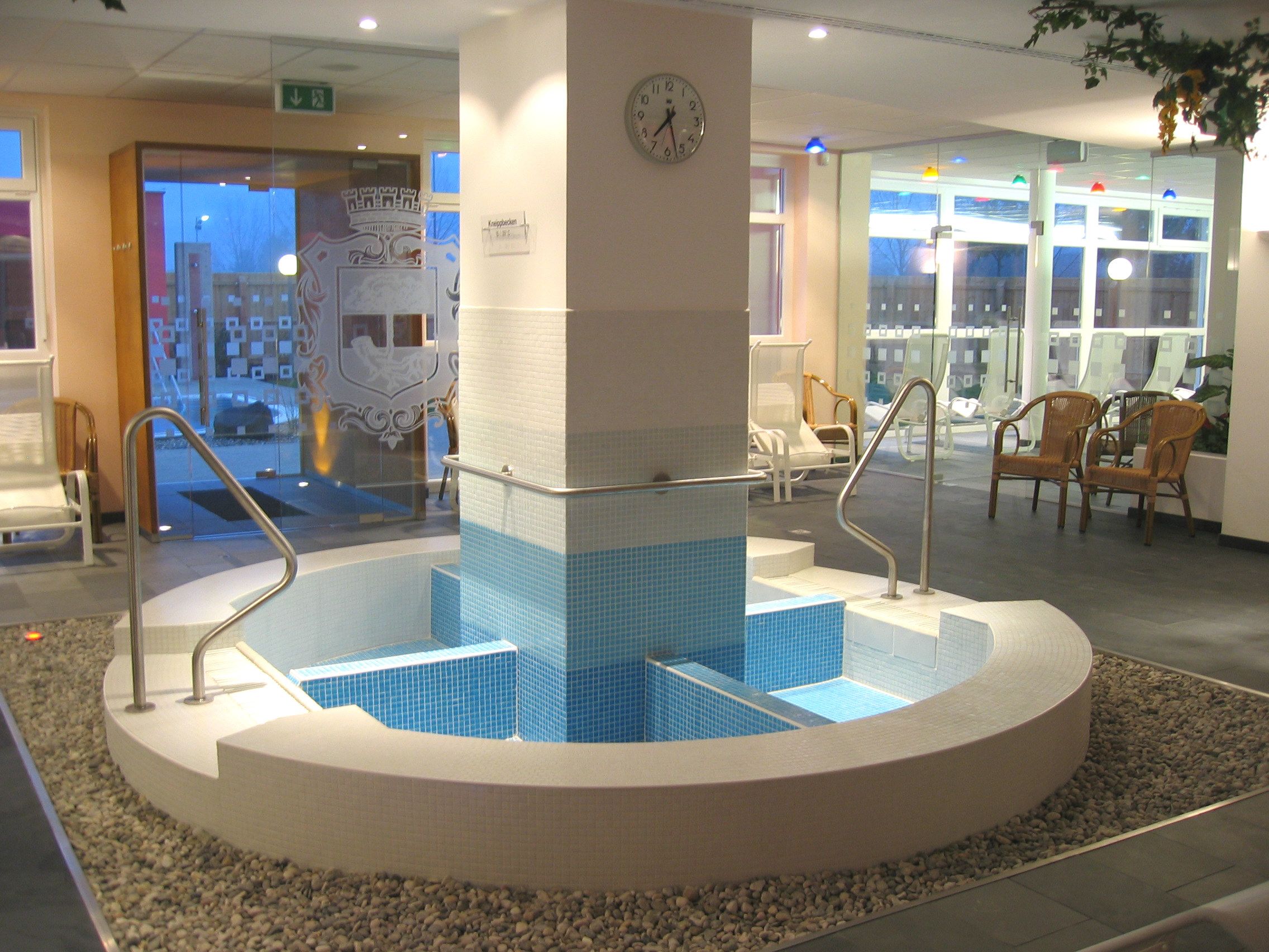 A stockeraui szabadidőközpont Kneipp-medencéjének belső nézete kék csempével és korlátokkal.