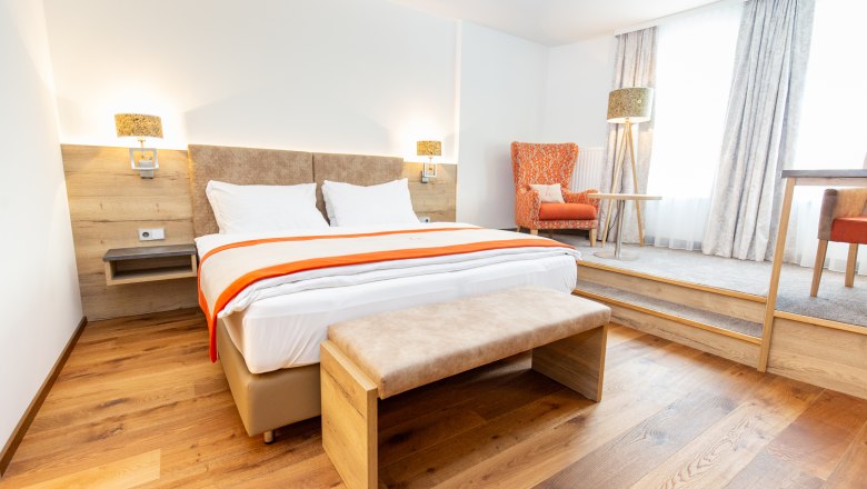 Ein Modernes Doppelzimmer mit einer extra Lese- und Schreibtischecke.