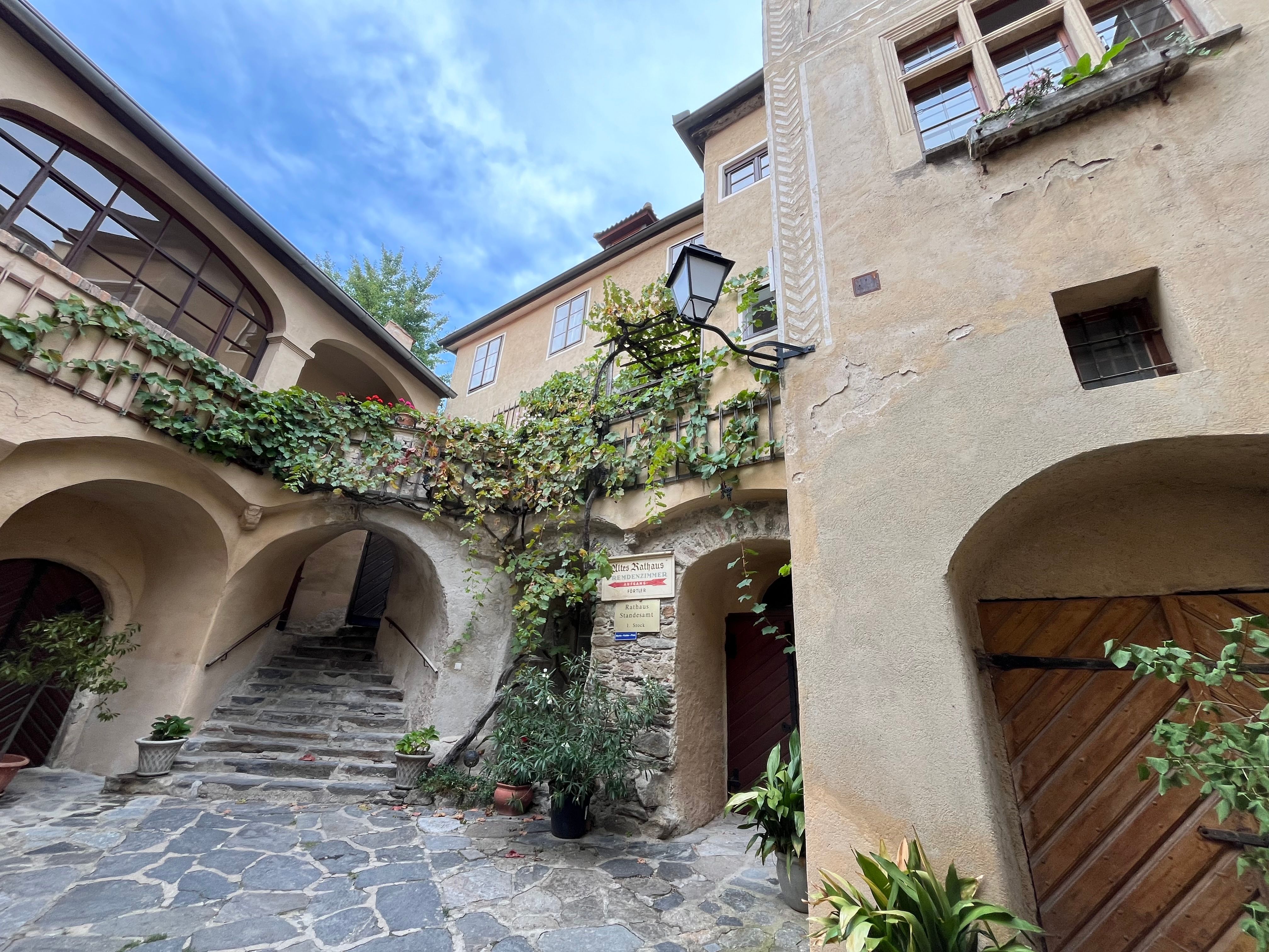 Történelmi épület árkádokkal és növényekkel Dürnsteinben.