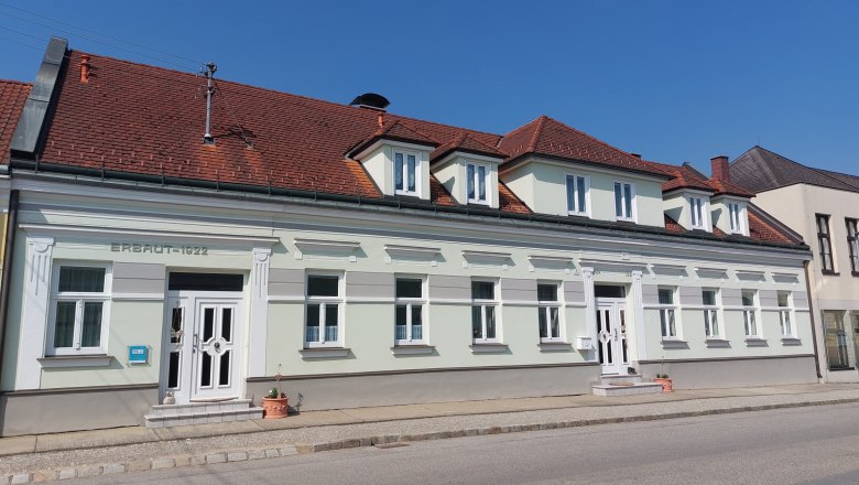 Napf&eacute;nyes időben, 1922-ben &eacute;p&uuml;lt k&eacute;tszintes &eacute;p&uuml;let, v&ouml;r&ouml;s cser&eacute;ptetővel &eacute;s feh&eacute;r ablakkeretekkel.