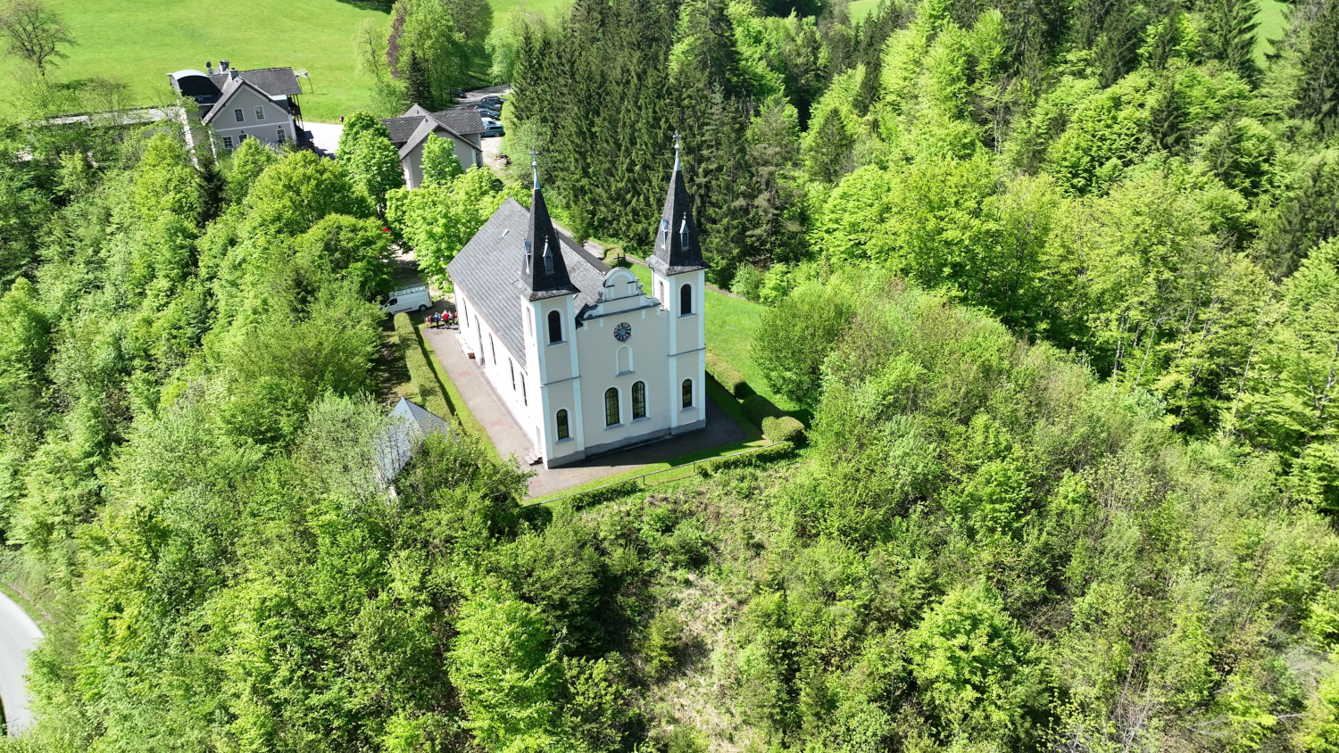 Légi felvétel a Maria Seesal zarándoktemplomról, amelyet zöld fák és erdők vesznek körül.