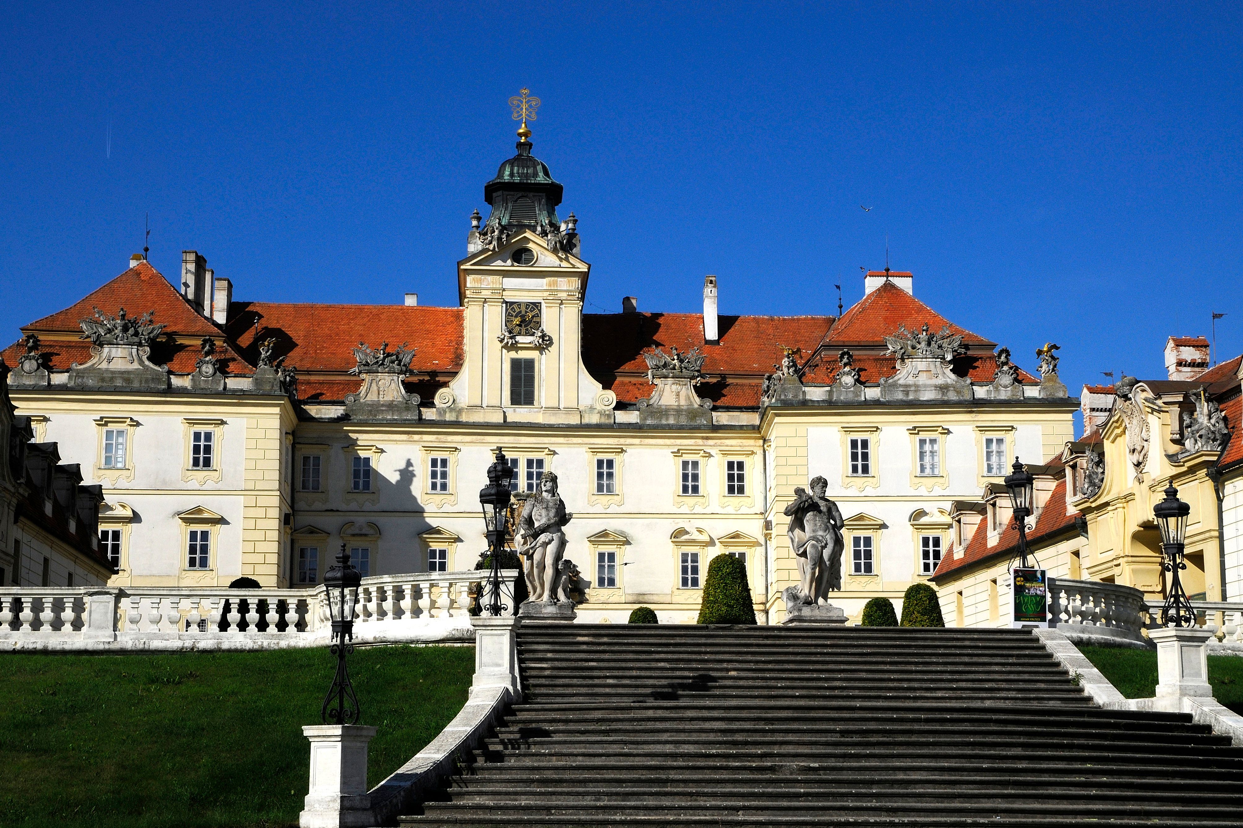 A Valticei vár elülső nézete, előtérben lépcsőkkel és szobrokkal.