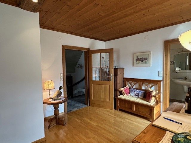 Fapaddal burkolt szoba, paddal, asztali lámpával és nyitott fürdőszobával.