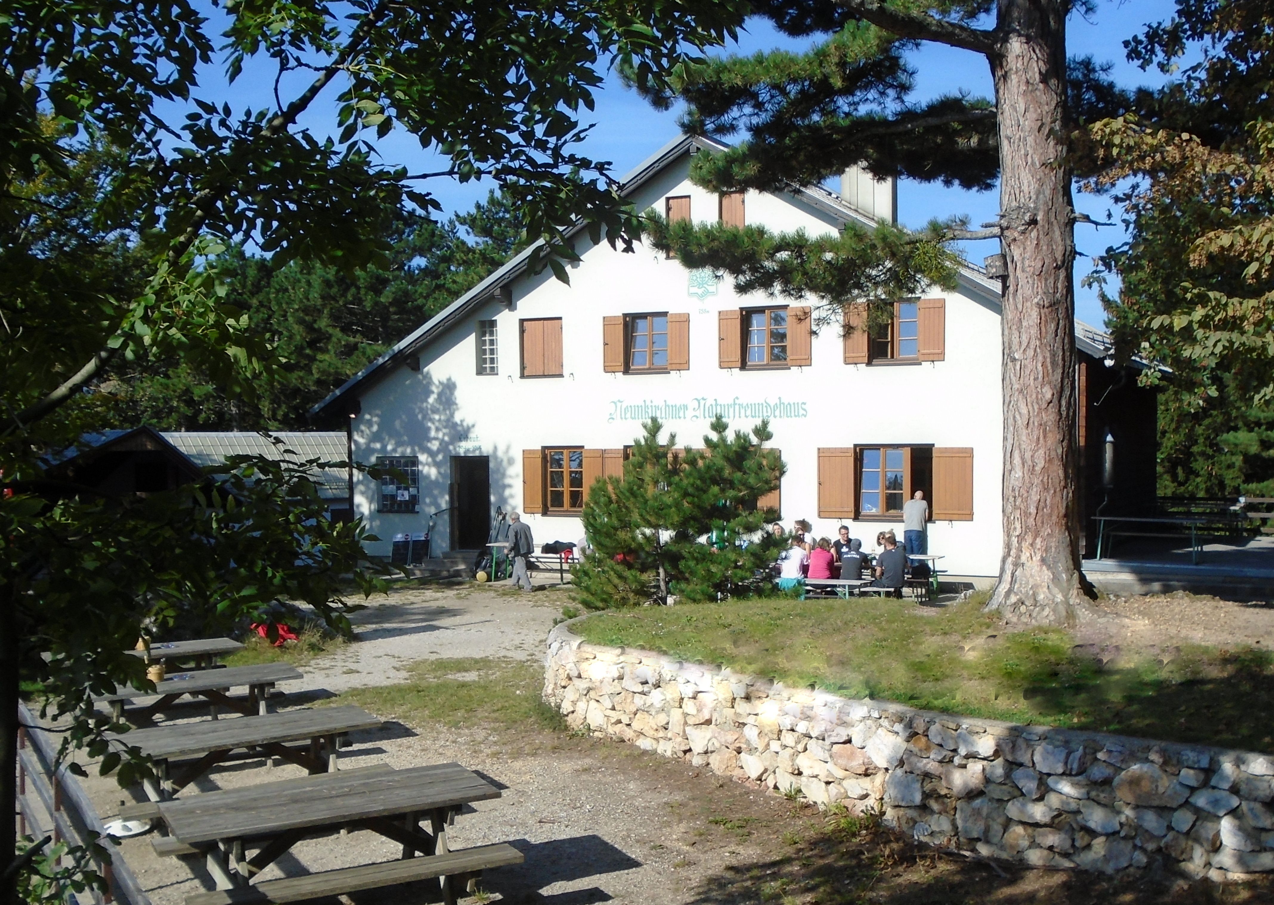 A Neunkirchen Naturfreundehaus külső nézete a szabadtéri ülőhelyekkel.