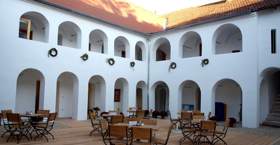 Az Eisenhuthaus belső udvara árkádokkal és fabútorokkal.
