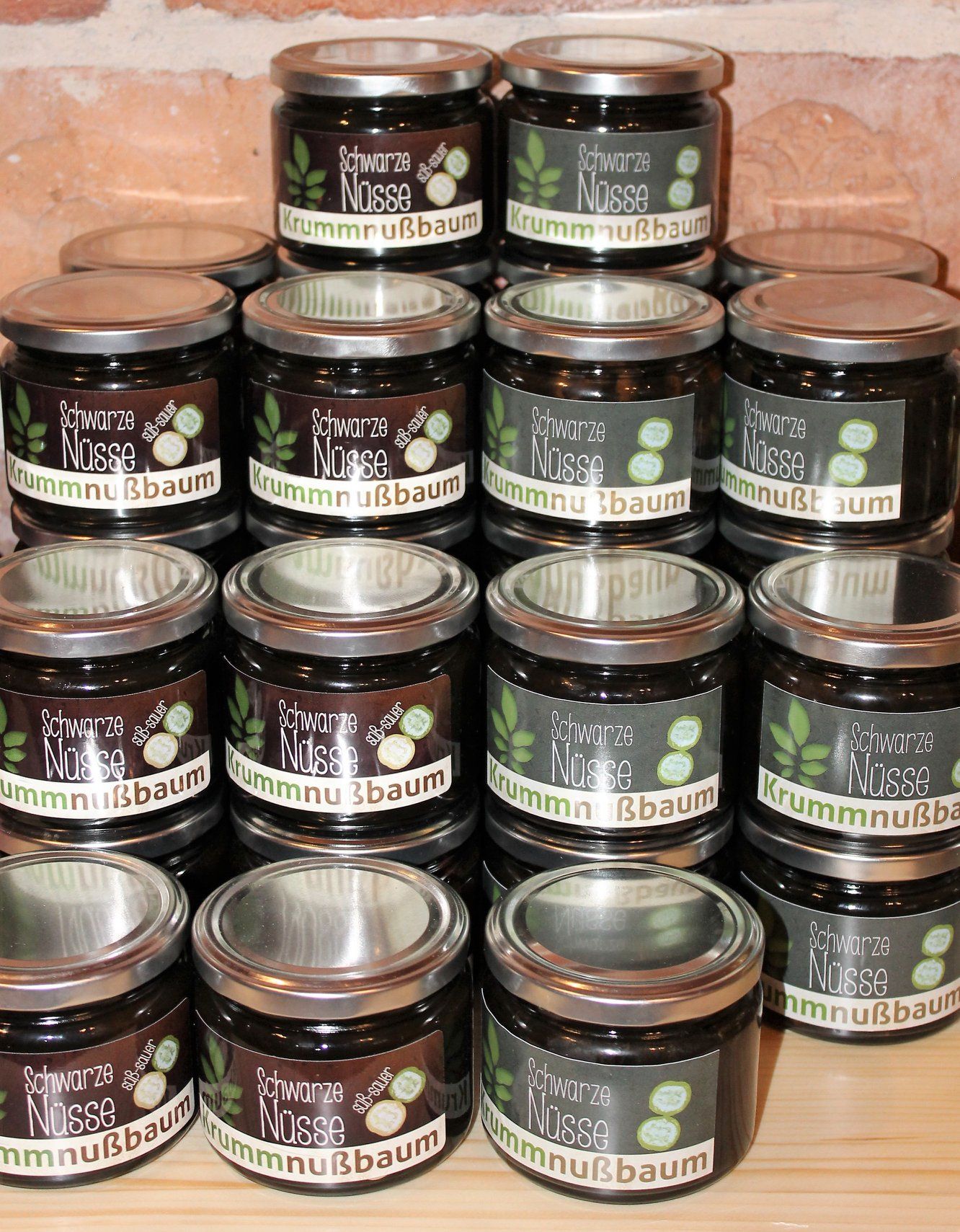 Egy asztalon több "Schwarze Nüsse Krummnußbaum" feliratú befőttesüveg halmozva.