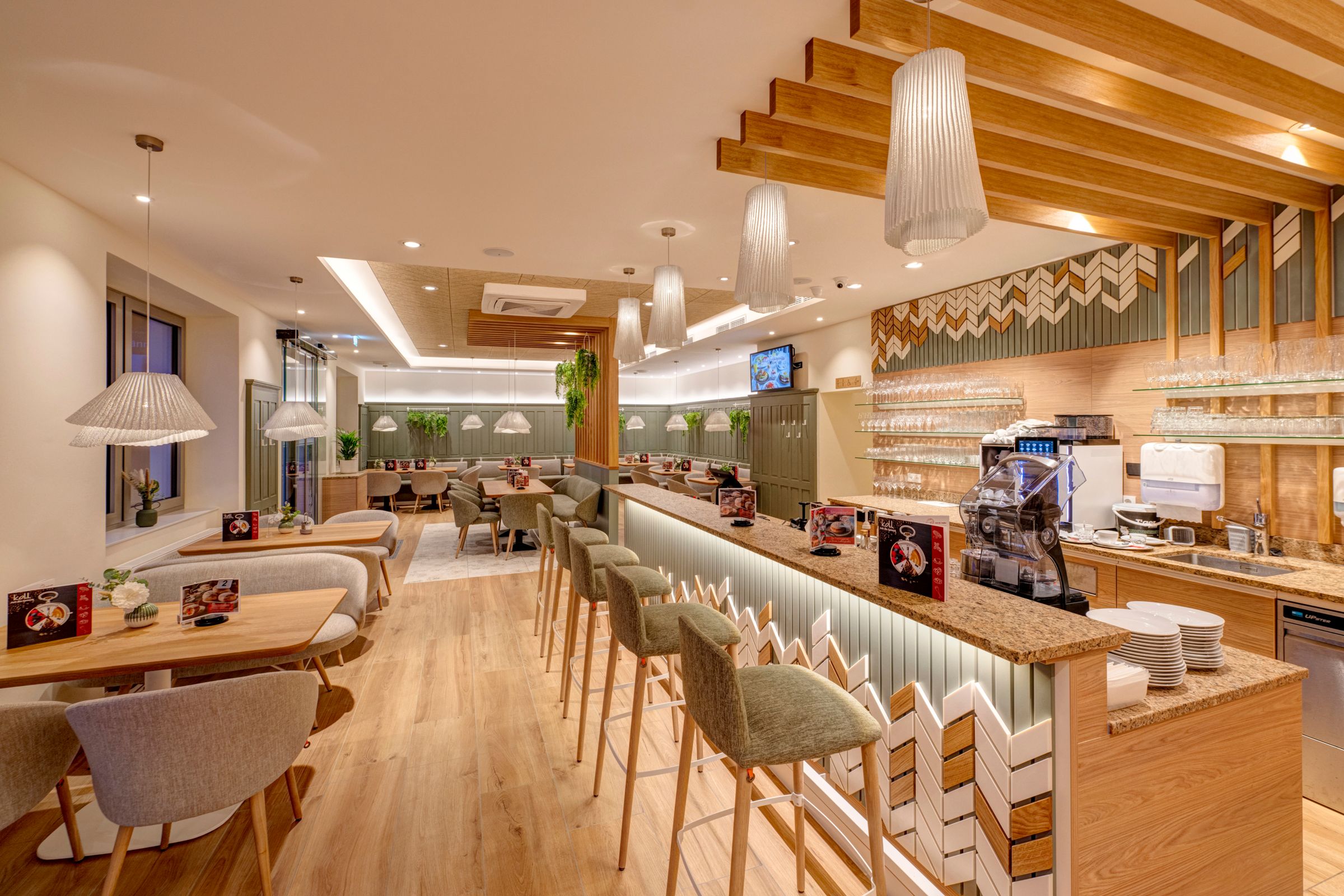 Modern kávézóhelyiség fából készült bútorokkal és bárral.