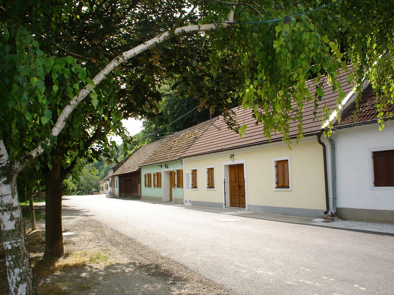 Csendes utca hagyományos házakkal és fákkal az Ahrenberger-Eichberger Pincesorban.