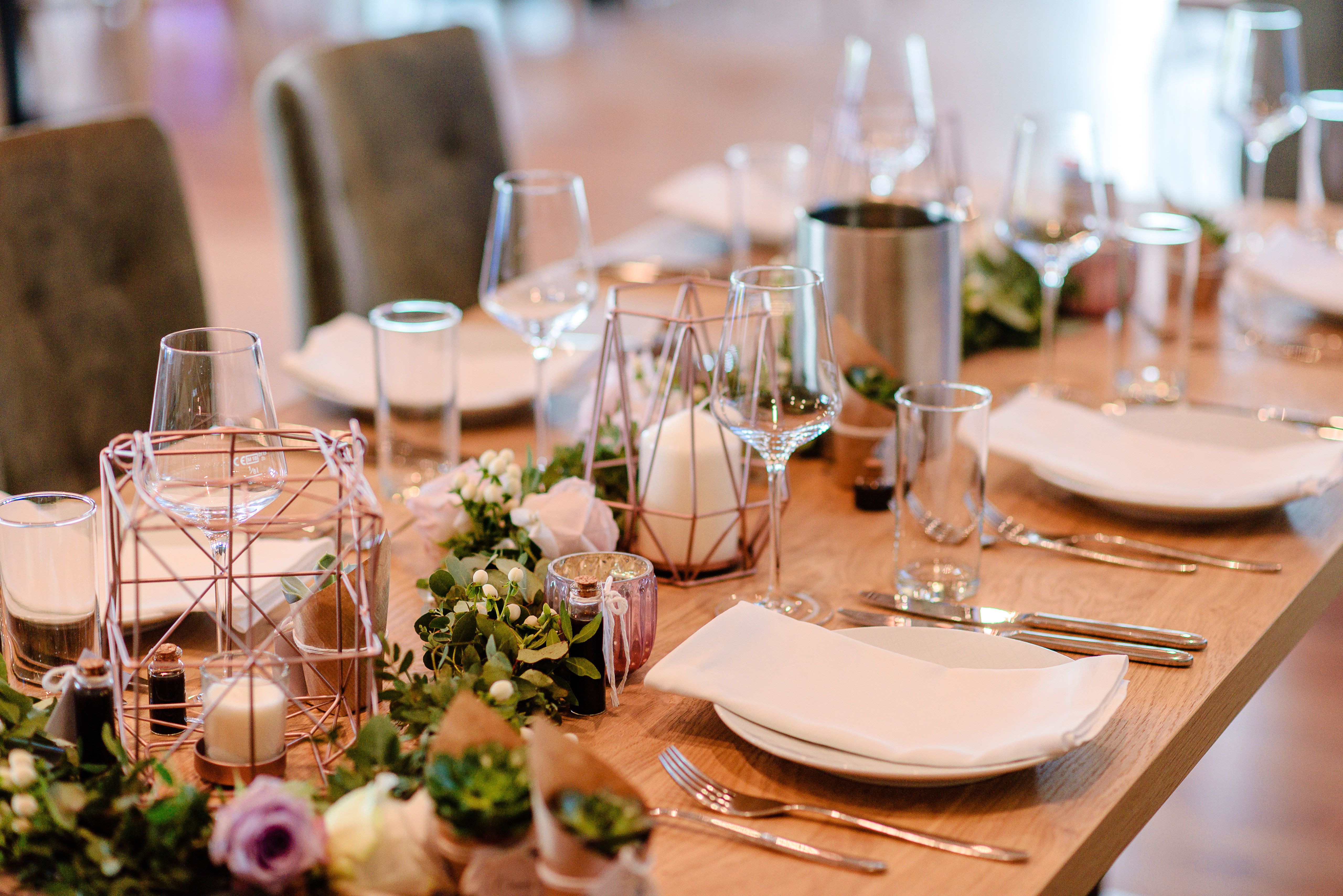 Elegáns esküvői asztal virágokkal és gyertyákkal.