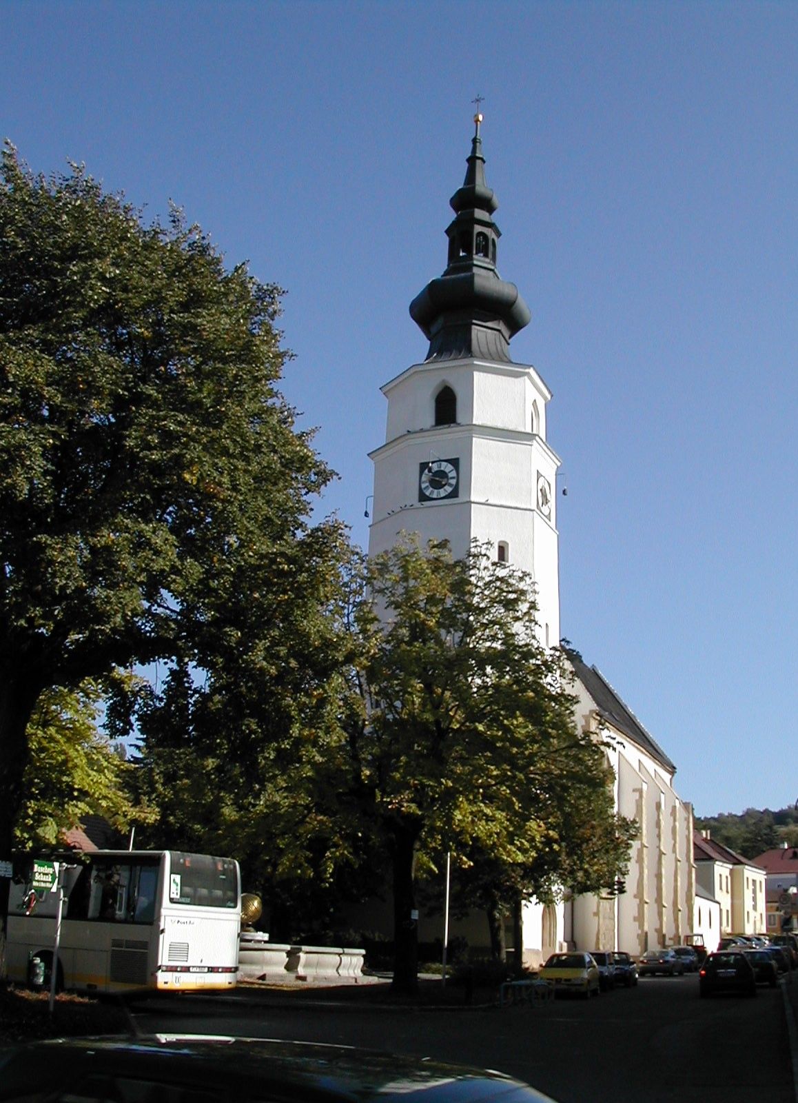 Königstetten plébániatemplom toronnyal és fákkal az előtérben.