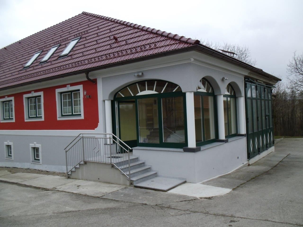 Modern épület piros tetővel és piros homlokzattal.