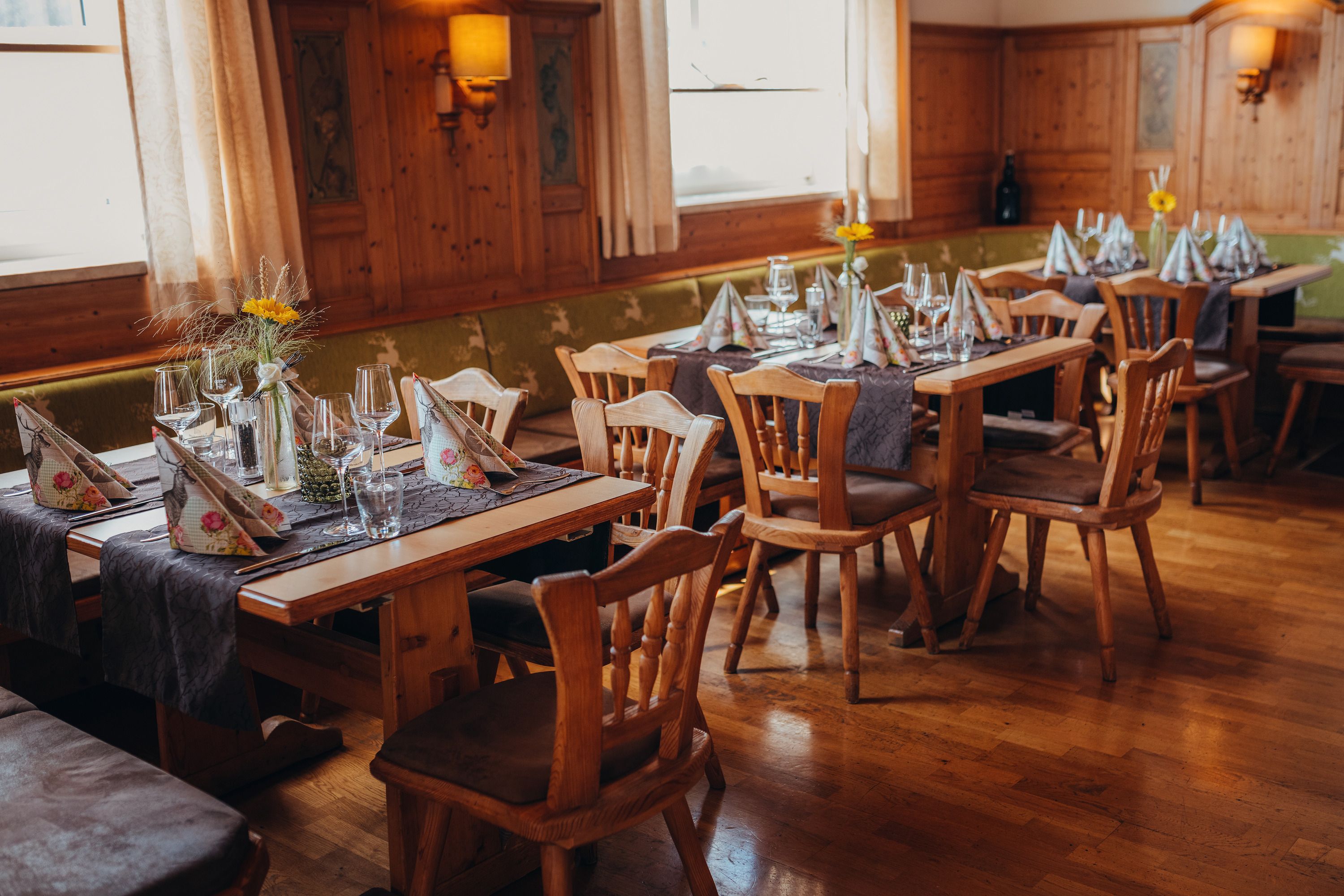 Hangulatos étterem fabútorokkal és terített asztalokkal.