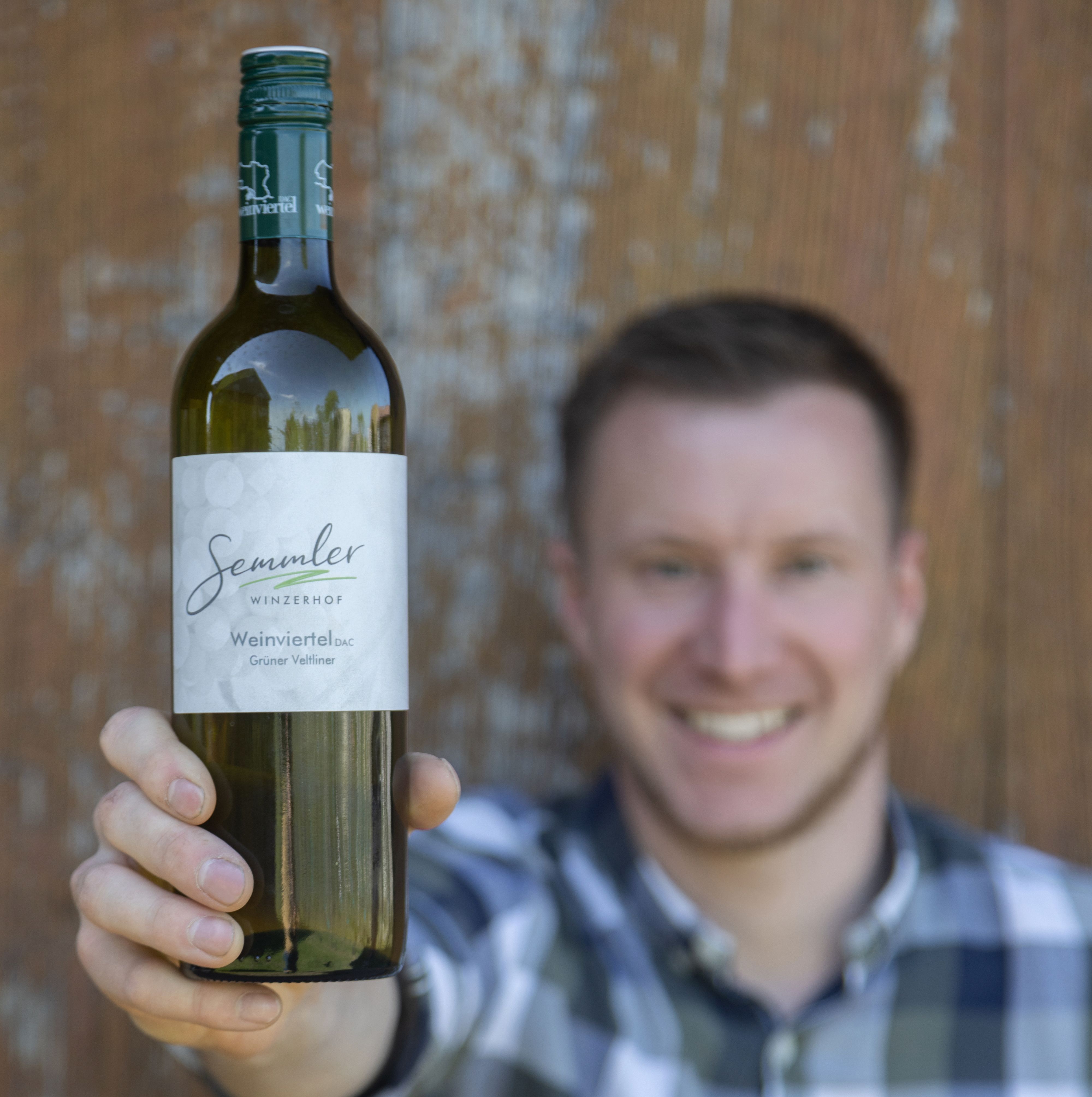 Egy férfi egy üveg Winzerhof Semmler bort tart a kamera felé.