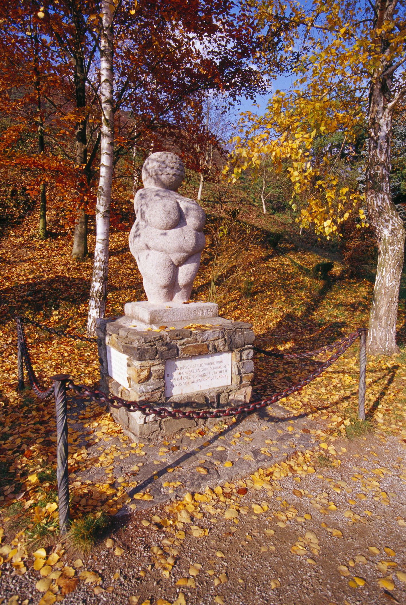 Vénusz a talapzaton, körülötte őszi levelekkel