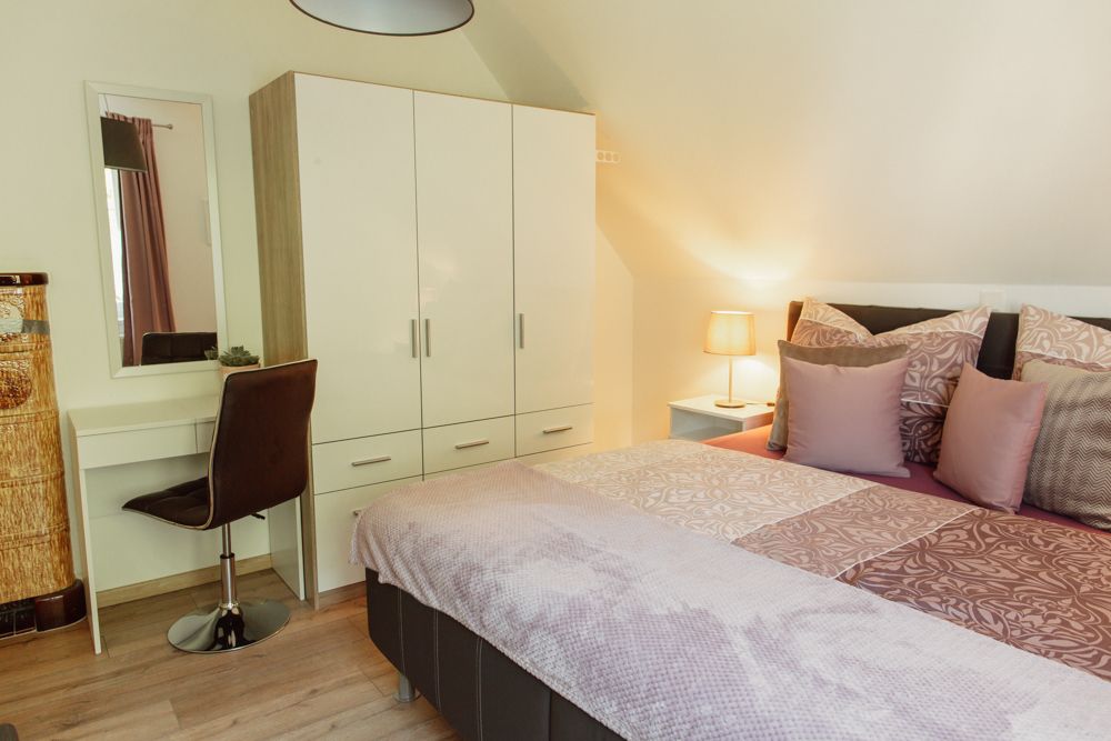 Hálószoba franciaággyal, szekrénnyel, öltözőasztallal és lámpával.