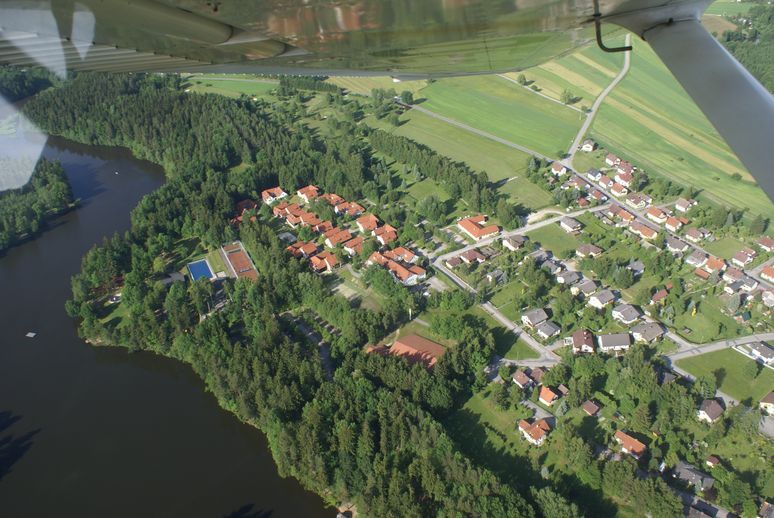 Légi felvétel egy golfpályáról és egy tóról a szomszédos lakóteleppel.