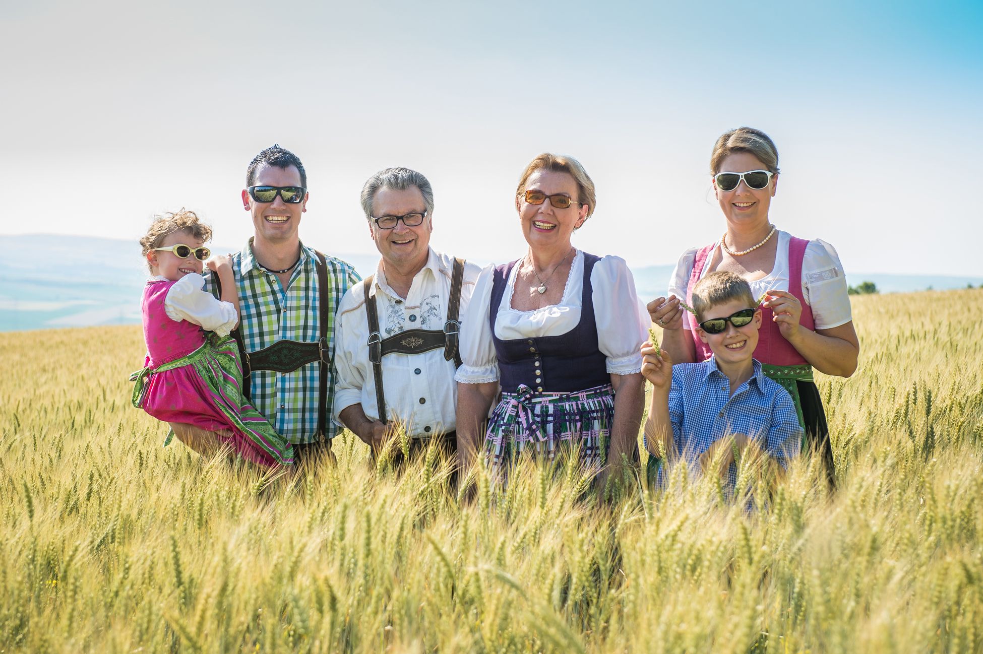 Familie Hopfeld in Tracht auf einem Feld.