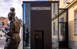 Eingang zur Kunsthalle Krems mit schwarzer Skulptur davor.