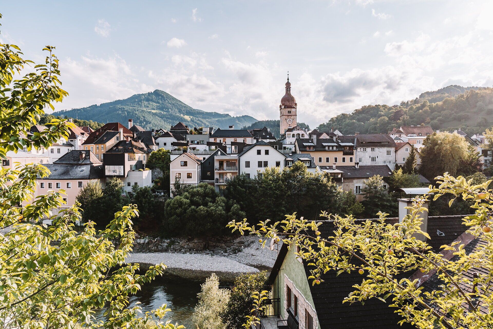 A képen Waidhofen an der Ybbs látható. A háttérben egy magas templomtorony és a Mostviertler Bergwelt látható.