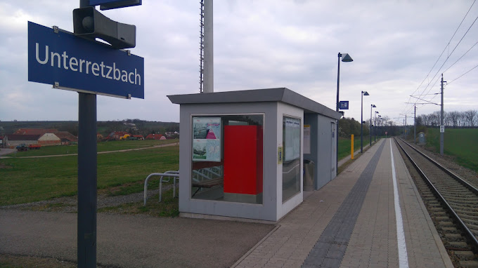Unterretzbach kis vasútállomás buszváróval és vasúti sínekkel.