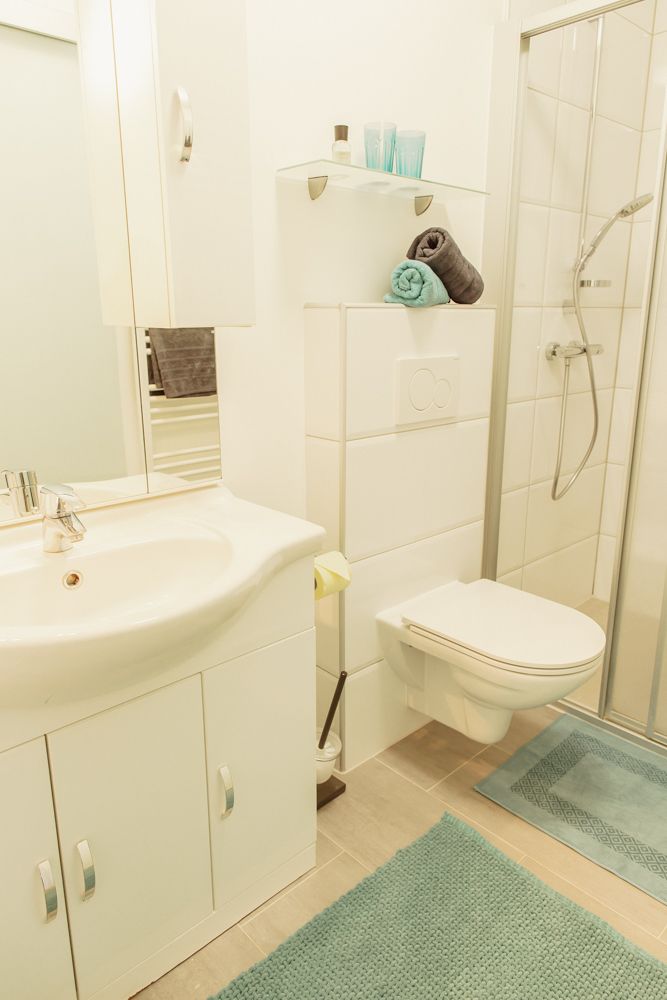 Modern fürdőszoba zuhanyzóval, mosdóval és WC-vel.