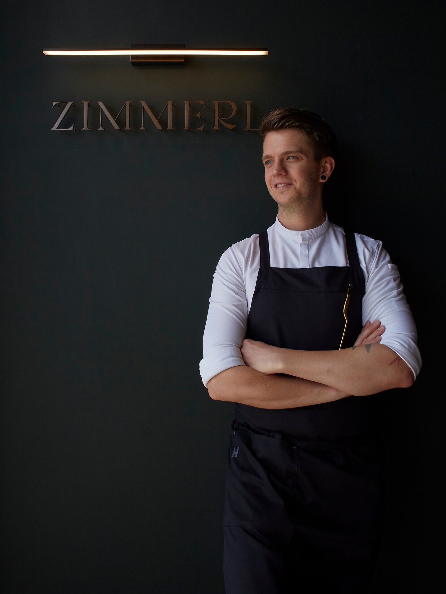 Elegáns étterem kerek asztalokkal, fehér terítőkkel és visszafogott világítással.