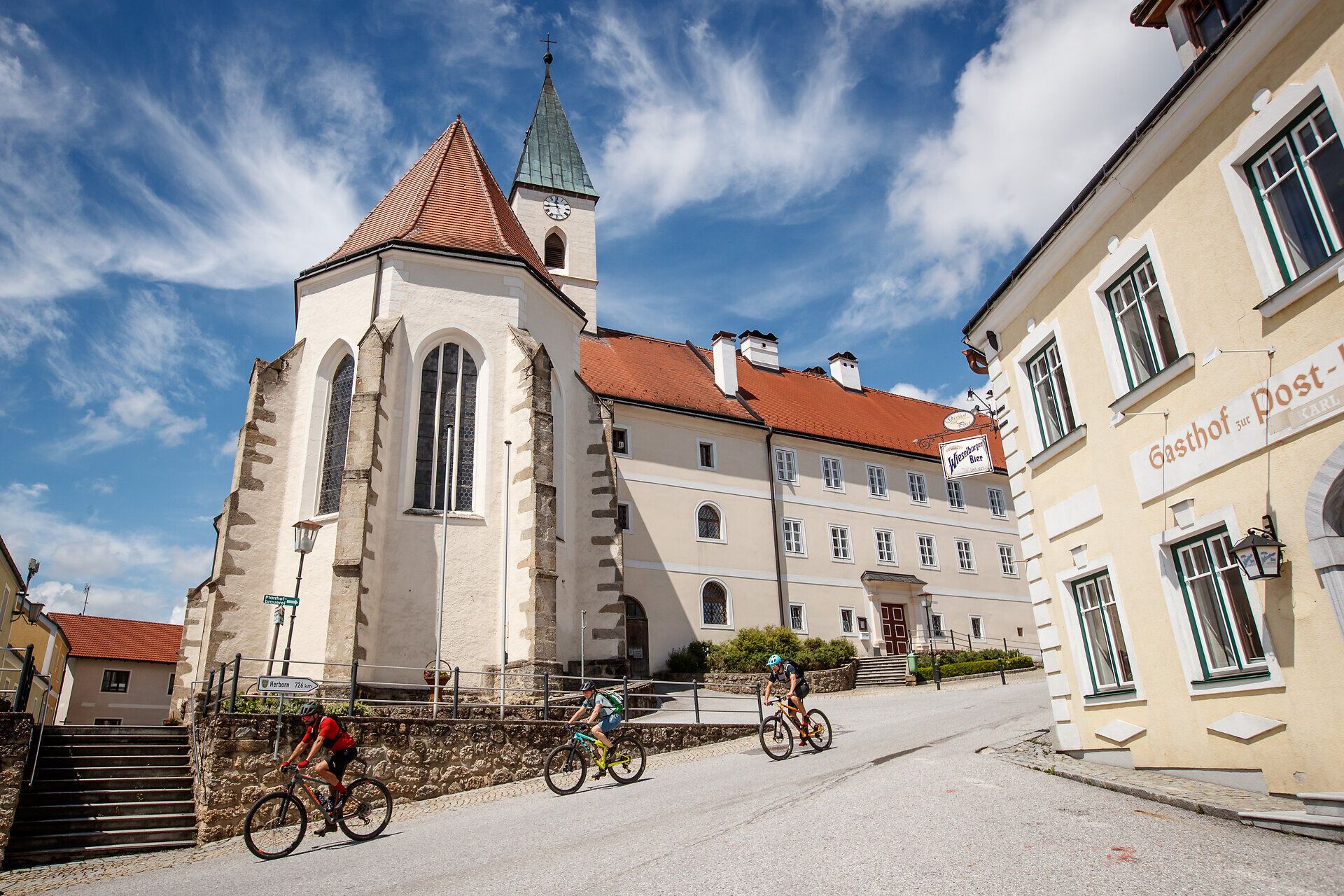 A hullámzó dombok felejthetetlen kalandra hívják Önt, míg a környék festői építészete harmonikus hátteret biztosít. A kerékpárosok felsiklanak az úton, hogy élvezzék a környező természet lélegzetelállító kilátását. Itt, ahol a hagyomány és a természet találkozik, minden pillanat élményt jelent.