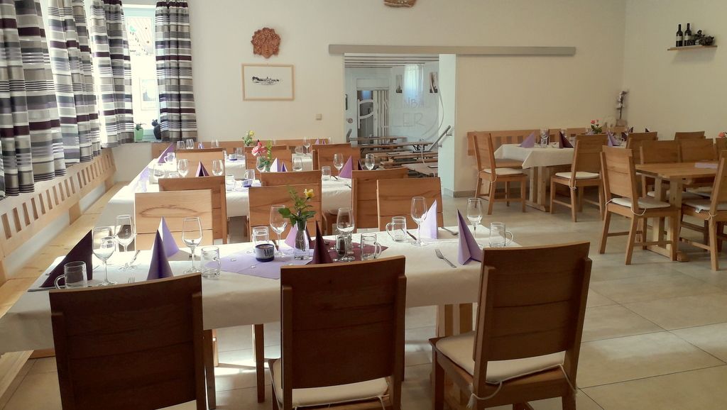 Egy hangulatos borozó belső nézete, terített asztalokkal és fabútorokkal.