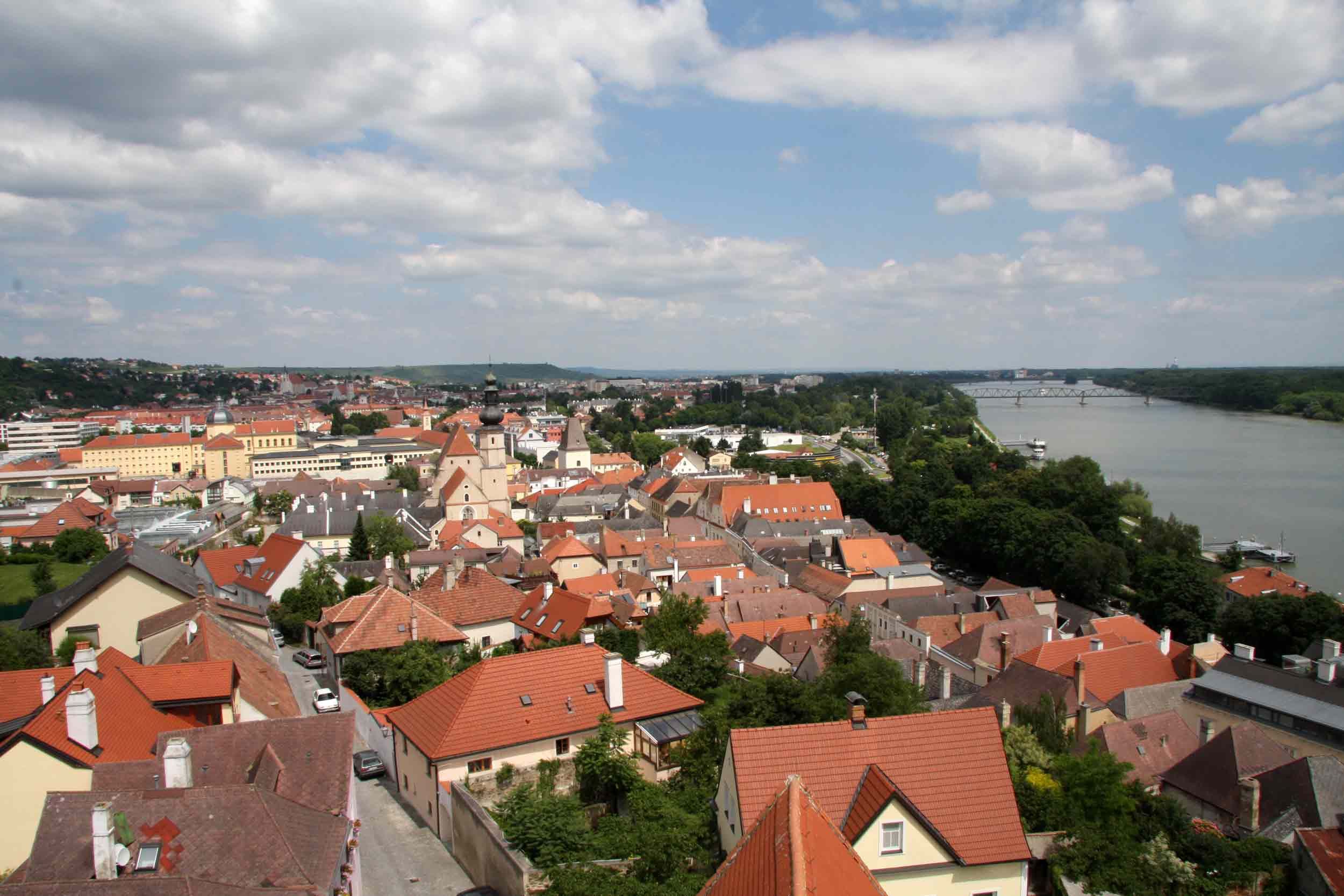 Krems háztetőinek panorámája a folyóval a háttérben.