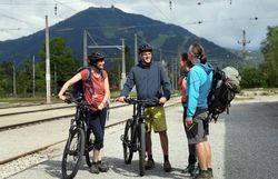 Eine Gruppe von Radfahrern genießt die frische Bergluft und die atemberaubende Landschaft. Umgeben von sanften Hügeln und üppigem Grün, strahlt die Szenerie eine einladende Atmosphäre aus, die zum Entdecken einlädt.