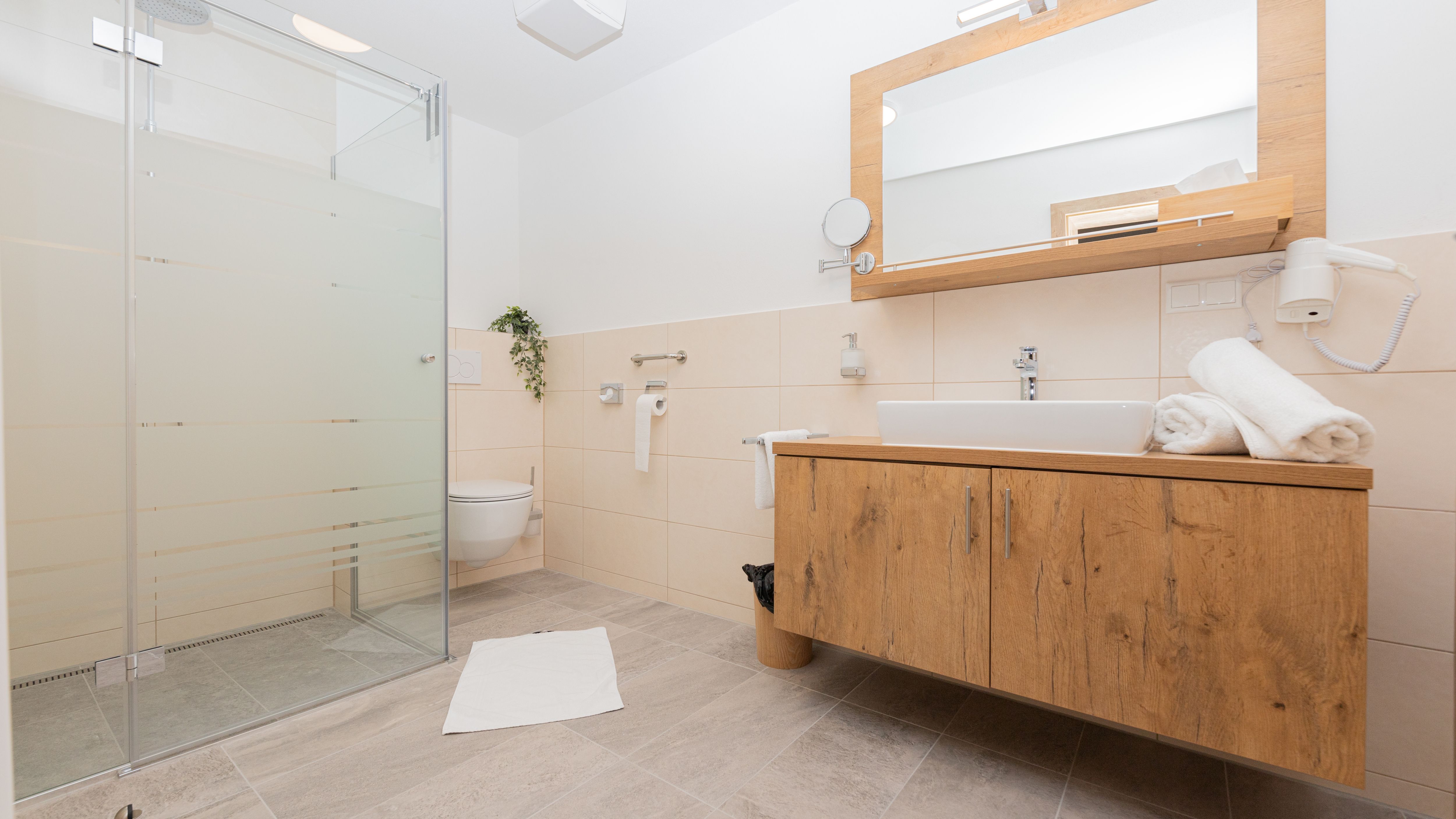 Modern fürdőszoba zuhanyzóval, mosdóval és WC-vel.