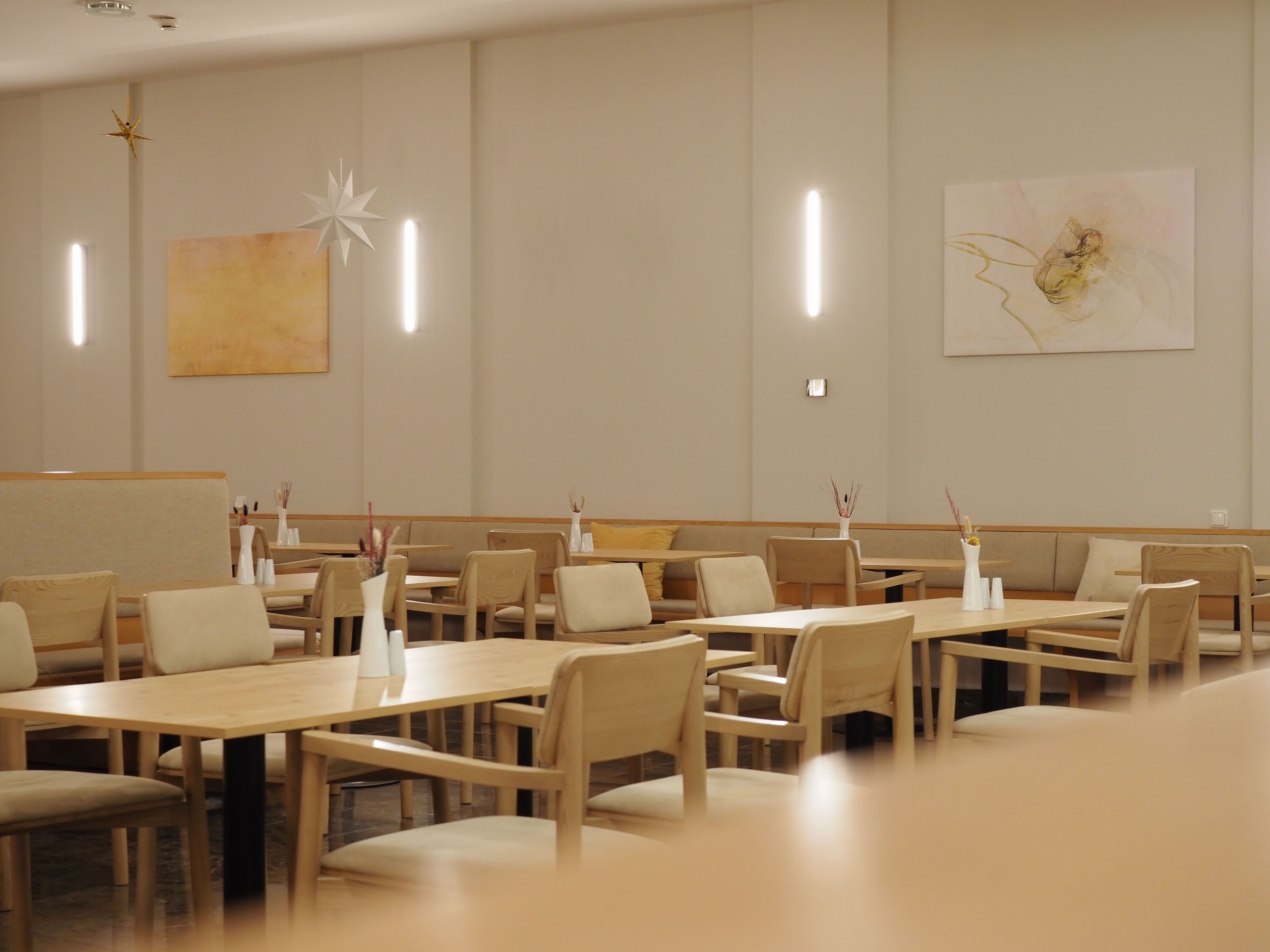 Egy modern étterem belső nézete, fa bútorokkal és minimalista dekorációval.