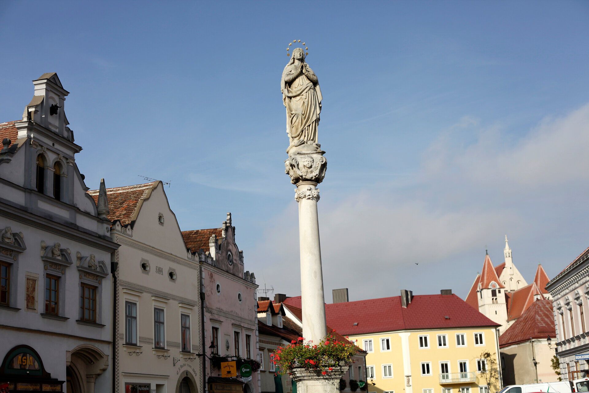 Szobor egy oszlopon Eggenburgban, háttérben történelmi épületekkel.