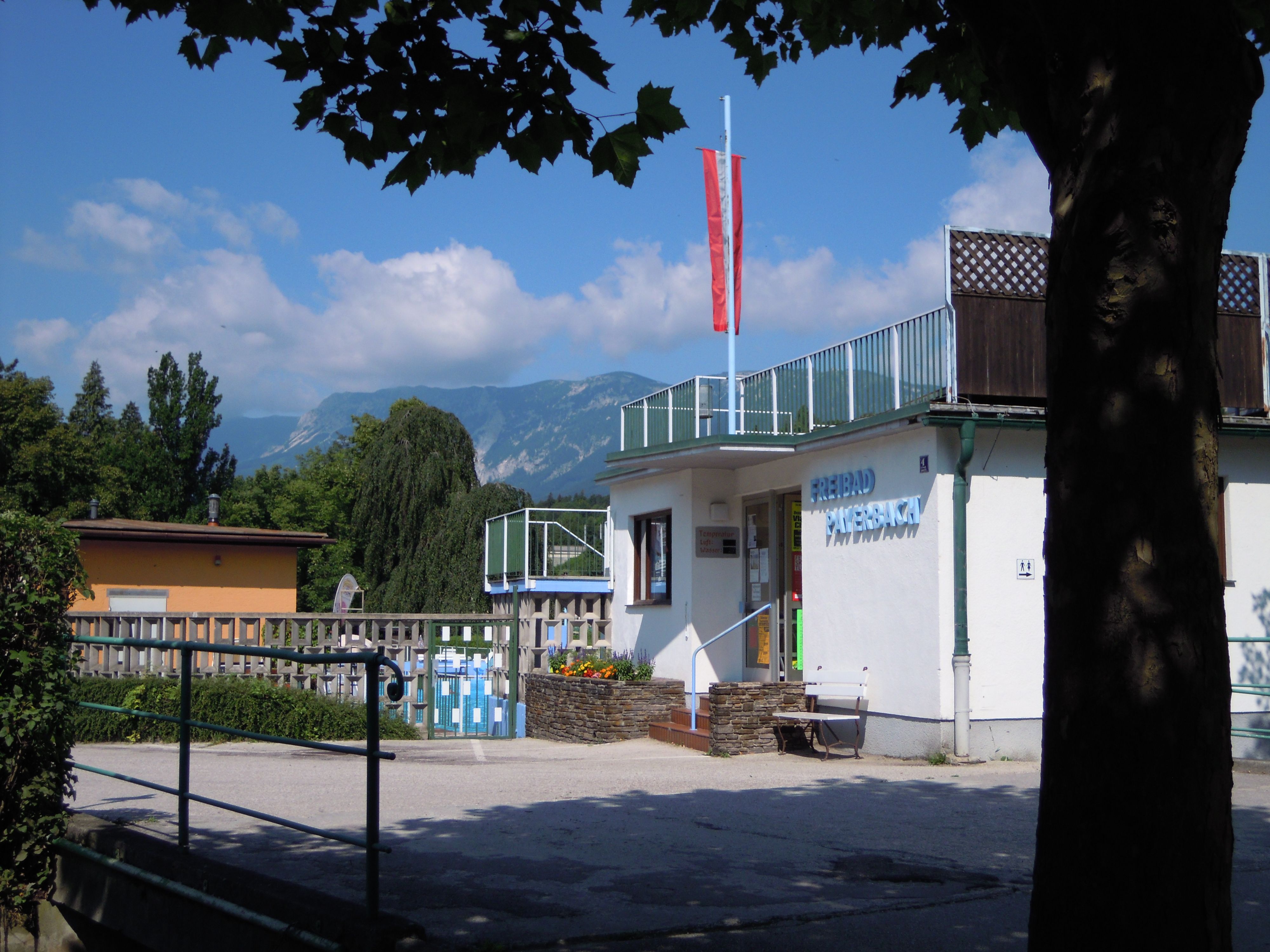 A Payerbach kültéri medence bejárata, háttérben a hegyvidéki táj.