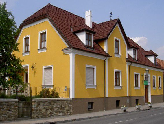 Sárga családi ház piros tetővel