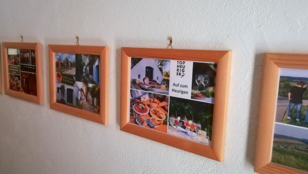 Képkeretek sora fényképekkel egy fehér falon.