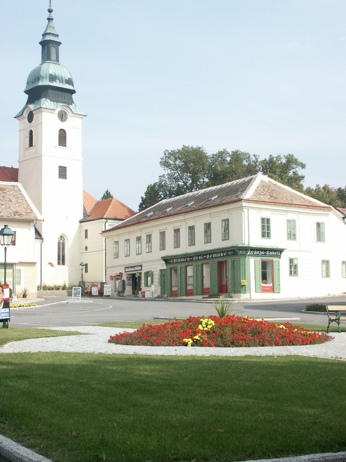 Sitzendorf an der Schmida főtere templommal és virágágyással.