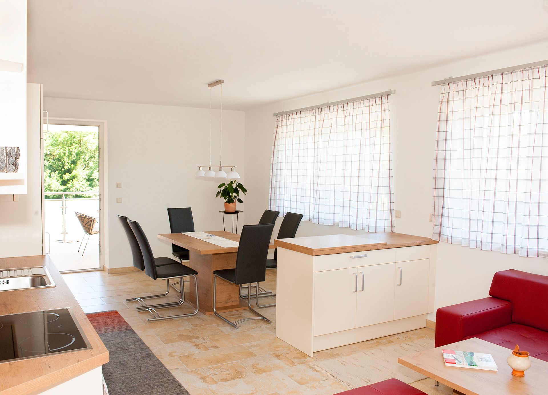 Modern étkező, fa asztallal, fekete székekkel és nagy ablakokkal, függönyökkel.