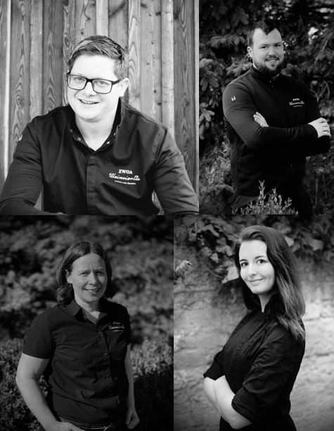 Négy ember fekete-fehér portrékon, mosolyogva, munkaruhában pózolva.