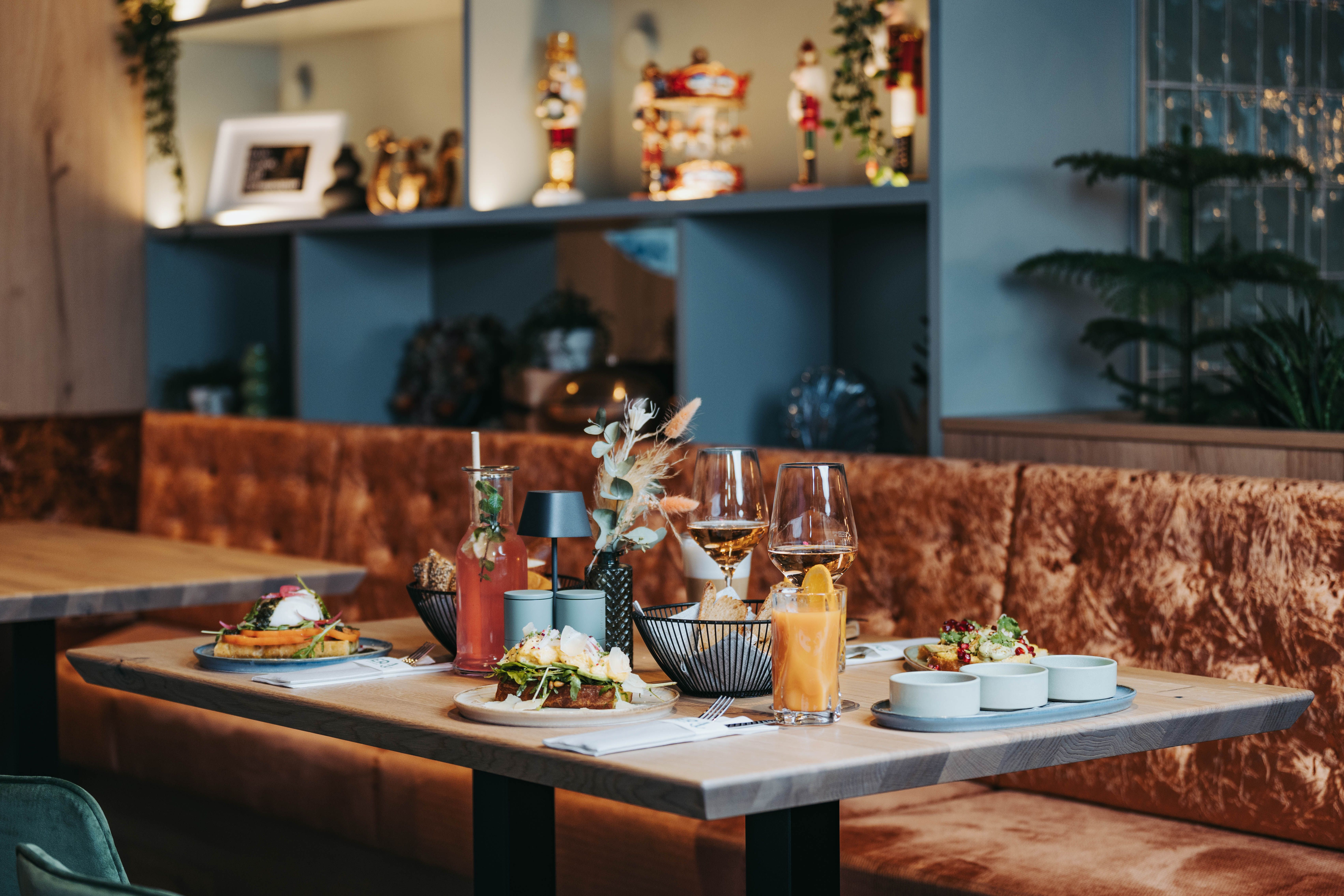 Terített asztal ételekkel és italokkal egy elegáns étteremben.