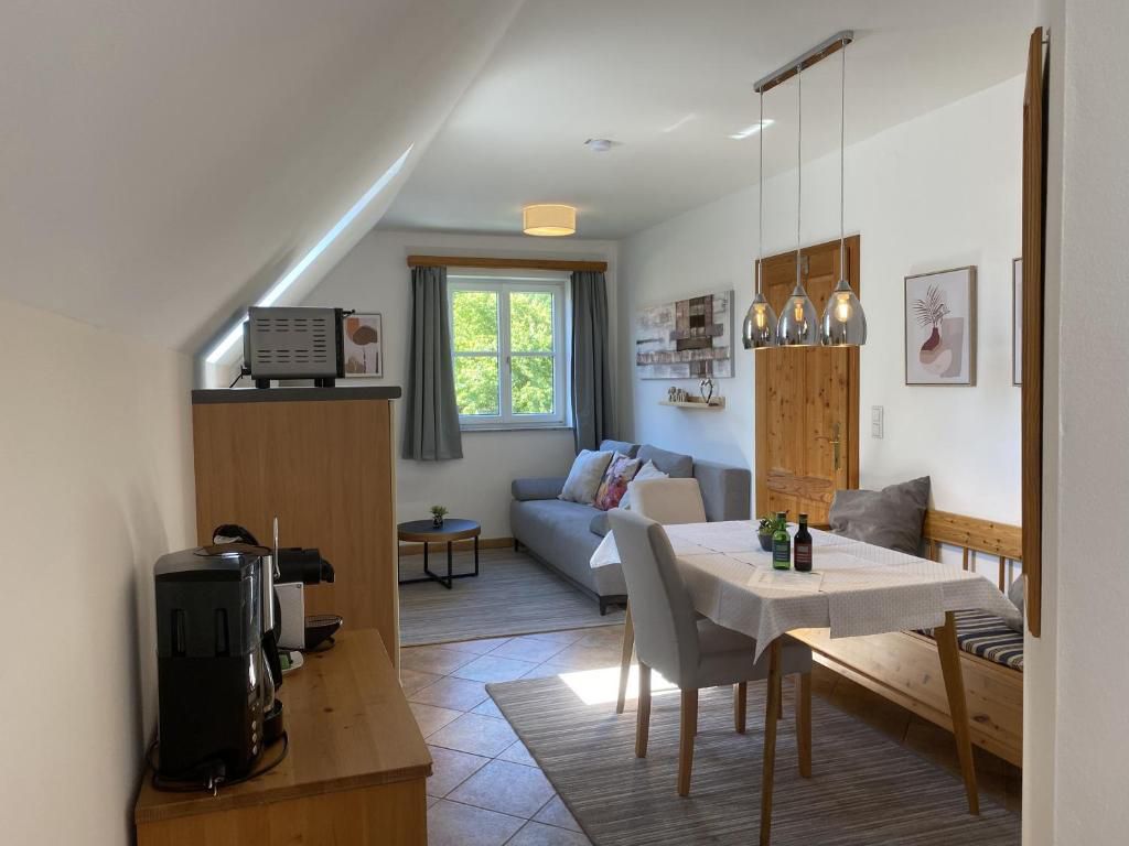 Hangulatos nappali étkezővel, kanapéval és konyhasarokkal, vidéki ház stílusban.