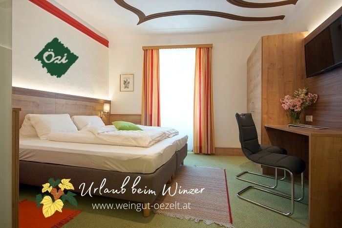 Hangulatos vendégszoba franciaággyal, íróasztallal és székkel, virágokkal díszítve. Világos színű függönyök és szőnyegpadló.