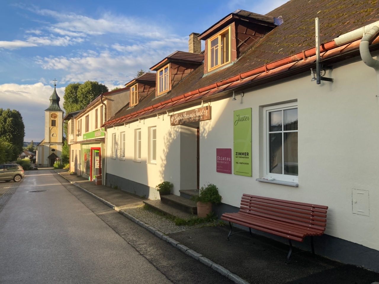 A Juster színpadi fogadó külső nézete, háttérben a templom.