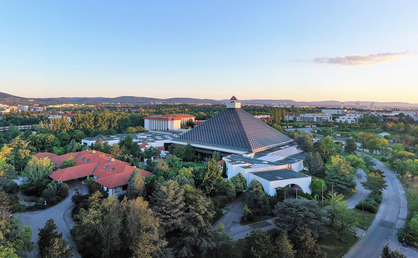 Légi felvétel a Pyramid rendezvényhotelről a környező tájjal és épületekkel naplementekor.