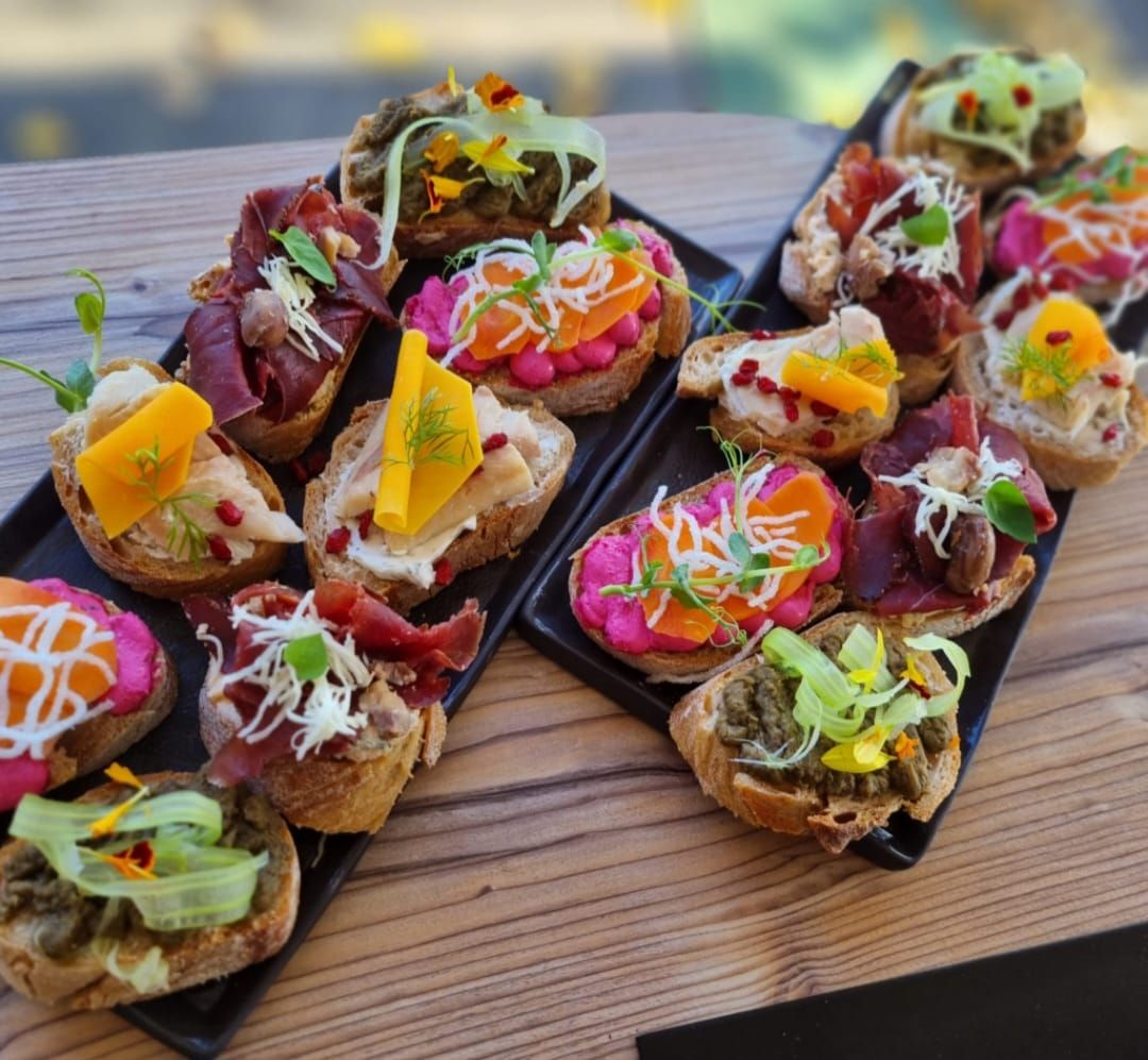 Különböző szendvicsek két fekete tányéron.