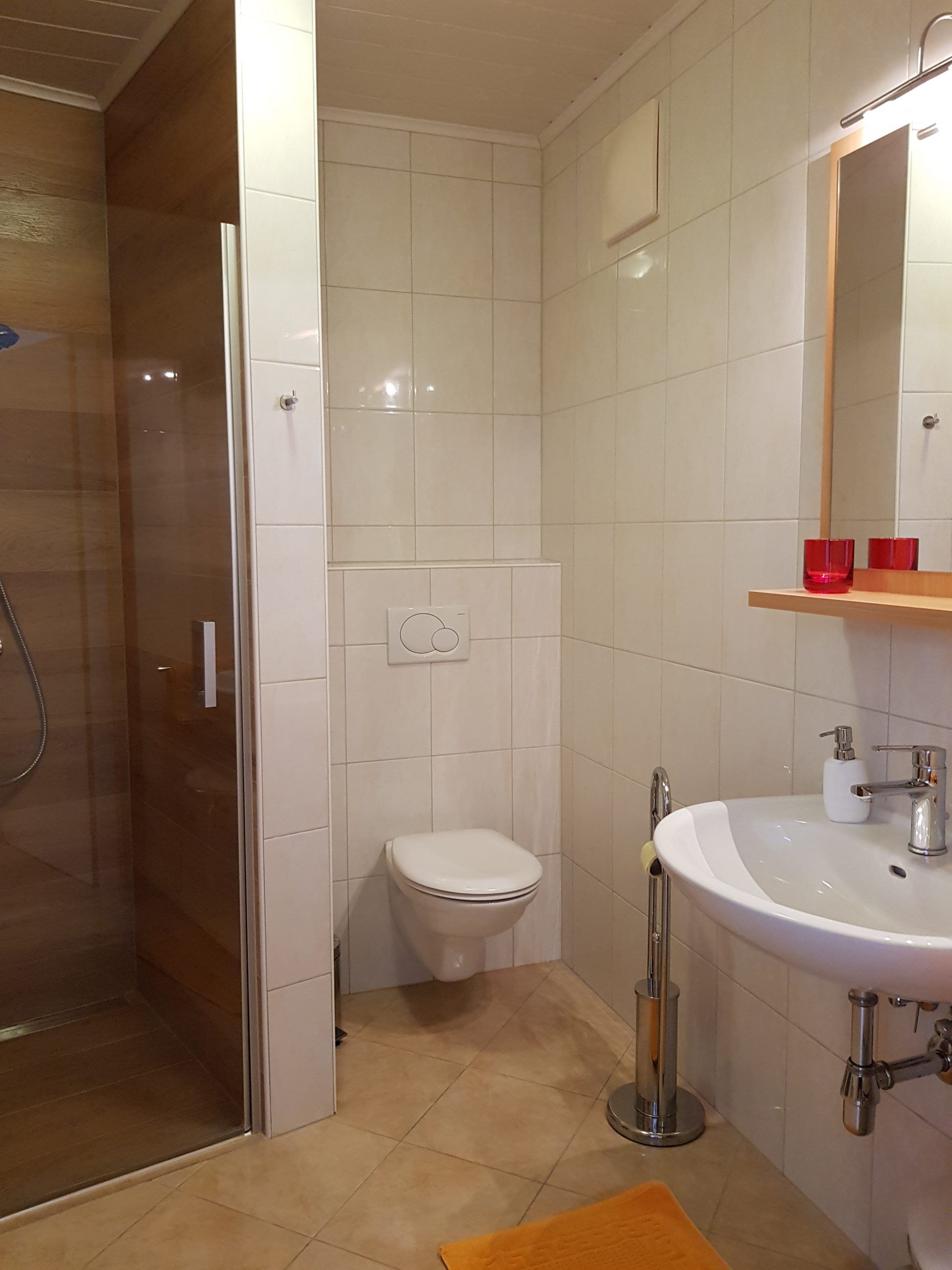 Modern fürdőszoba zuhanyzóval, WC-vel és mosdókagylóval.